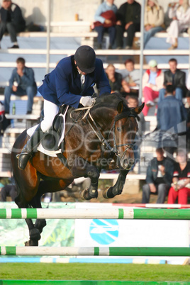 The jockey jumps through an obstacle