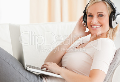 Blond-haired woman watching a movie on her laptop