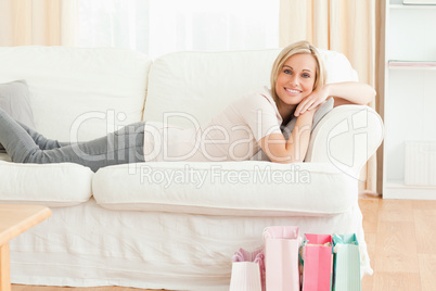 Woman lying on her couch after shopping
