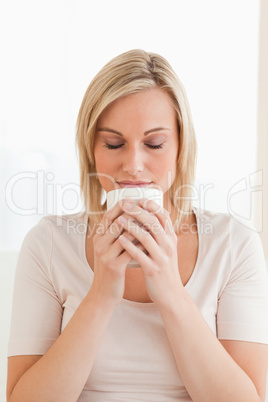 Portrait of a woman smelling her cup of coffee