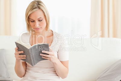 Fair-haired woman reading a book