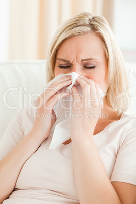 Portrait of an ill woman blowing her nose
