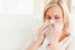 Ill woman blowing her nose