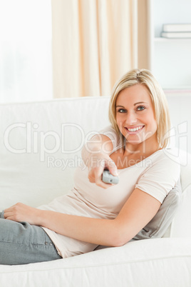 Portrait of a woman using a remote with a knowing smile