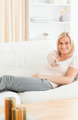 Portrait of a smiling woman using a remote