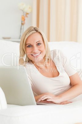 Portrait of a cute woman using a notebook in her living room