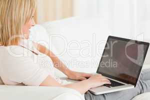 Close up of a blonde woman using a notebook