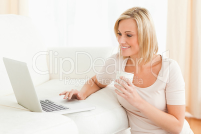 Woman holding a mug while using a laptop