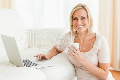 Woman holding a mug while with a notebook