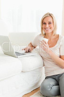 Portrait of awoman holding a mug while with a notebook