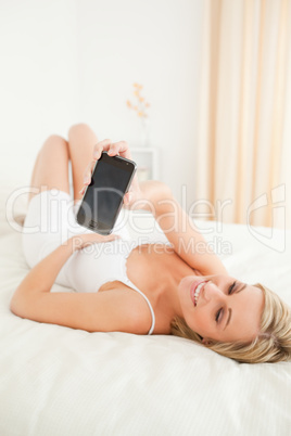 Portrait of a cute woman showing her smartphone