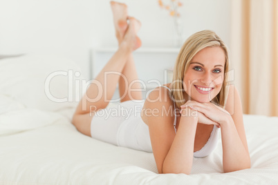 Blonde woman posing on her bed