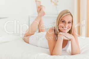 Blonde woman posing on her bed