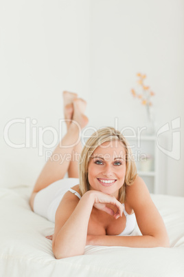 Portrait of a smiling woman lying on her bed