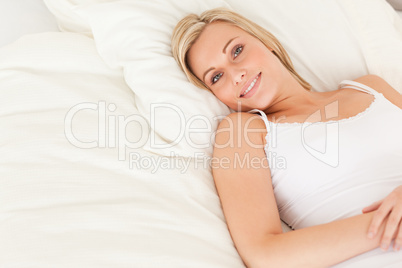 Blonde woman lying on her bed