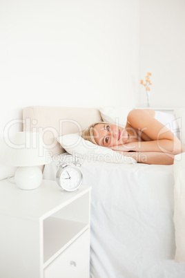 Portrait of a woman waking up and an alarm clock