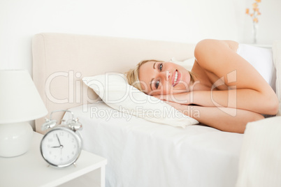 Woman waking up and an alarm clock