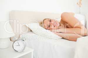 Woman waking up and an alarm clock