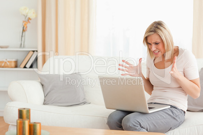 Close up of an upset blonde woman using a laptop