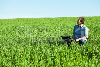 young man using laptop in the field