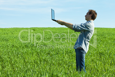 young man using laptop in the field