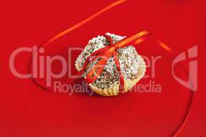 cake topped with coconut bandaged tape on a red background