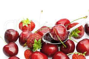 cherry and strawberry in a spoon isolated on white