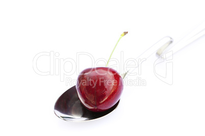 cherry  in a spoon isolated on white