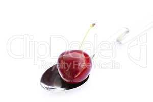cherry  in a spoon isolated on white