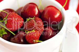 cup  cherry and strawberry on a red background