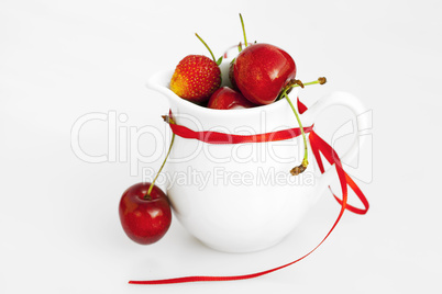 milk jug ribbon  cherry and strawberry isolated on white