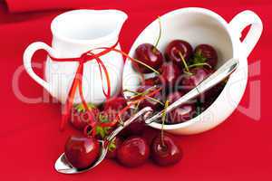 milk jug with a ribbon spoon   cherries and strawberries in a wh
