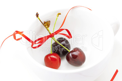cherry with ribbon in the cup isolated on a white