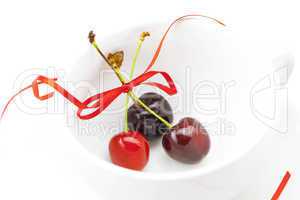 cherry with ribbon in the cup isolated on a white