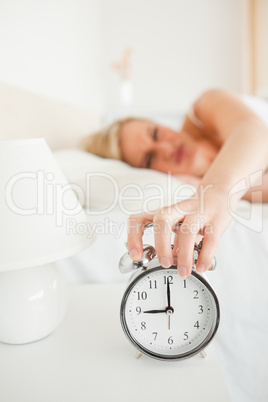 Portrait of a woman switching off her alarm clock