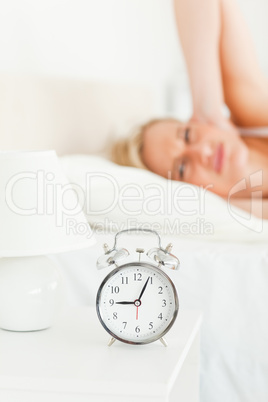 Portrait of an upset woman awaked by her alarm clock