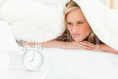 Disgruntled blonde woman waking up
