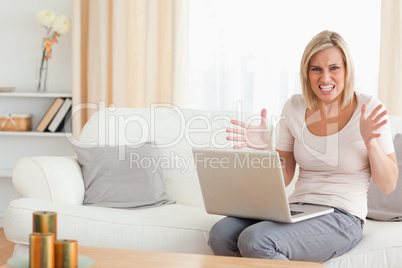 Angry blonde woman using a laptop
