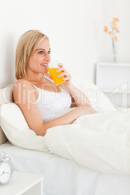 Portrait of a blonde woman drinking juice