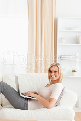 Portrait of a woman with a laptop while lying on a sofa Portrait of a woman with a laptop while lying on a sofa