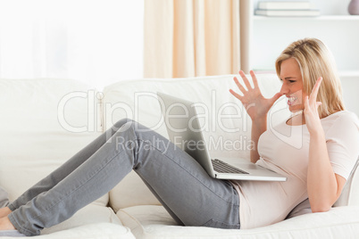 Unhappy blonde woman having trouble with her laptop