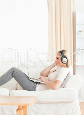 Portrait of a smling woman watching a movie with her laptop