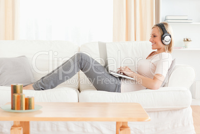 Blond-haired woman watching a movie with her laptop
