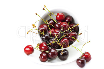 cherry in a cup and saucer isolated on white