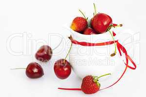 milk jug ribbon  cherry and strawberry isolated on white