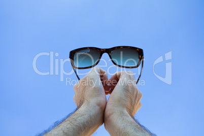 Glasses  in the hands against the sky