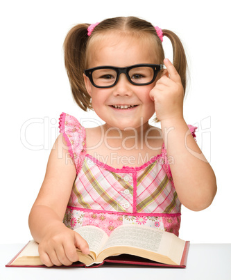 Little girl is flipping over pages of a book