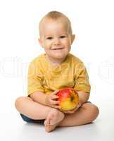 Cheerful little boy with red apple