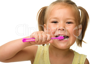 Little girl is cleaning teeth using toothbrush