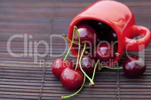 cherry  and cup  on bamboo mat